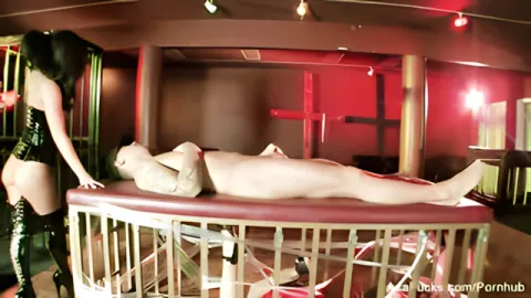 Mistress in a corset fucks hard with a slave on a cage with a slave