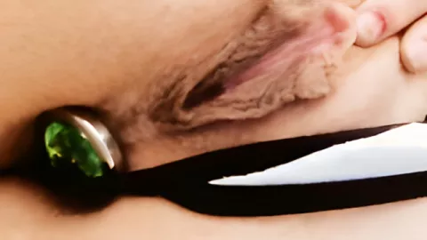 Caressing with the fingers of a shaved pussy with a plug in the folder
